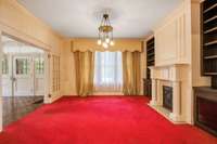 Formal living and dining rooms with original unfinished hardwood flooring under the wall to wall carpet and pad.