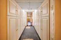 Hallway with cabinets for storage.