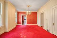 Formal living and dining rooms with original unfinished hardwood flooring under the wall to wall carpet and pad.