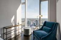 Imagine sipping your morning coffee in this cozy bedroom nook, overlooking the city as it begins to stir.