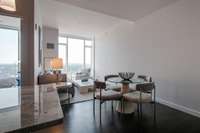 In this previously staged photo, notice the ease of entertaining as guests flow between the kitchen island, adjacent dining area, and seamlessly into the living room.