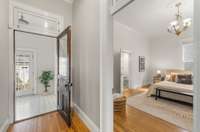 The back of the hallway leading to the mudroom with back door (ahead) and to the primary bedroom (right).