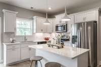 The bright white kitchen has great views of the treed back yard.