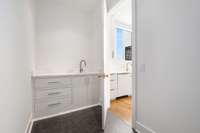 The laundry room includes built-in cabinetry and a utility sink.