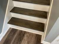 Four wooden steps that go up to 3 bedrooms and 2 full baths.