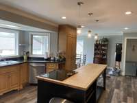 Love the new light fixtures. The door space on right goes down few steps to another primary bedroom/full bath with enlarged walk-in closet. You can see the chairs there is a table there, too. This is dining area - if you want to use it there.