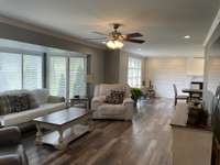 Another view of the living room. All new flooring in entire house (no carpet). Waterproof LVP floors on main & secondary level. New lights fixtures, new fans. All blinds remain. The ceilings are smooth ones - they had the popcorn ceilings removed.