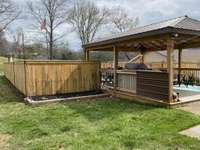 A sump pump was installed on this side of fence in midway yard (covered with a grate) so standing water will not happen.