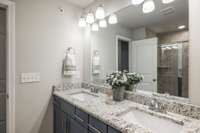 The primary suite bath has double sinks and lots of cabinet storage. Don't you love the granite counter tops?