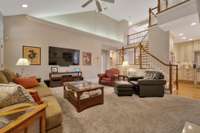 Another view of the family room shows the unique staircase and it is open to the kitchen..