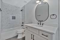 Modern & refined yet soothing & inviting, this bathroom has a shower/tub combo & easy access to a walk-in closet & flex space beyond.