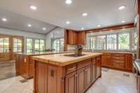 The large preparation island topped with butcher block helps to make meal prep easy.