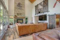 A closer look reveals the detail of the stone fireplace.  There's an overlook with real barn doors above from one of the guest bedrooms which guarantees even more views of the lake.