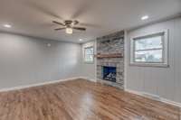 Den with stone fireplace and hardwood floors. Fireplace is propane.