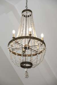 The architectural ceiling within the primary suite is flattered with an ornate & elegant beaded chandelier.
