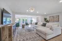 Living Room with clean lines, fresh white paint, designer lighting and white oak LVP flooring