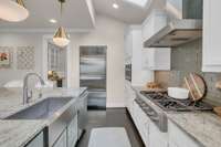 Kitchen has top of the line appliances including a 6 burner Monogram range