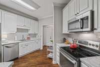 The kitchen boasts stainless steel appliances and tile back splash.