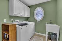 Laundry room with cabinets and cleaning sink