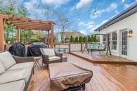 Large deck and pergola overlooks the fully fenced in yard and swimming pool