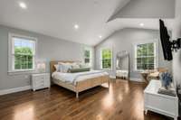 Upstairs the primary bedroom is a serene retreat with vaulted ceiling.