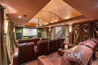 Theater room with stadium seating and surround sound.