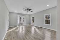 Living Room measures 20x14 and has LVP flooring and lots of natural light. Recessed can lighting as well as a ceiling fan. There is a pass through to the Kitchen.