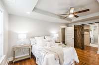 Hardwood flooring and a tray ceiling are great adds in this space.