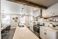 Bright white cabinets with quartz counters and back splash really make this kitchen area pop!