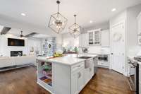 This open floor plan is ideal for entertaining!  Expansive island and high-end lighting.  Notice the open-end shelves, adding storage just where it is needed.