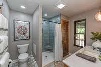 Bathroom features custom tiled floors and fully tiled shower