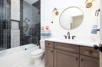 Secondary bathrooms include Quartz or Granite counter-tops with oval undermount sink, 12x24 designer tile floor & tile tub surround to ceiling with framed glass tub/shower enclosure.