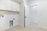 Cabinets above washer and dryer provide room for additional storage.