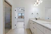 Primary bathroom with double vanities and large walk-in shower.