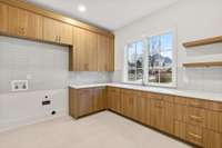 Amazing laundry room on the main level. So much storage and counter space with a granite composite sink!