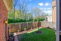 A well-manicured, fenced backyard area serves as a private retreat including a rose garden. It's the perfect space for your morning meditation or for children or pets to play in a safe, enclosed space while you keep a watchful eye from indoors.