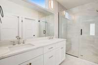 The primary bathroom features a stunning frameless shower, double vanity sink and a custom walk-in closet.