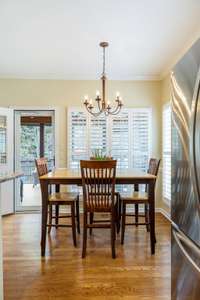 The breakfast room sits snugly in a windowed corner under a charming light fixture.