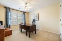 Calming beige walls and energy-efficient plantation shutters enhance another private upstairs bedroom.