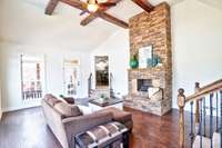 Check out this open and airy den with floor to ceiling stone fireplace that leads out to your backyard!