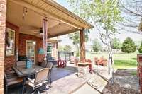 Step through the side gate into the backyard and the covered patio with firepit area.