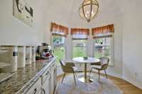 Enjoy birdwatching as you sip your favorite coffee in this charming eat-in kitchen spot, offering a perfect view through the bay window and basking in delightful natural light.