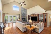 Very high ceiling in the living room with stack-stone wood-burning fireplace, built in entertainment center, gorgeous hardwood floors and incredible views out the back.