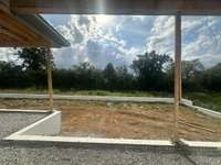 View of spacious backyard with lots of privacy and mature trees. Sod and irrigation included. photo taken 7/20/24