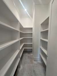 View of walk-in kitchen pantry with lots of shelving. *this home is under construction 9/18/24