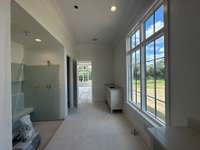 Primary Spa bath featuring double vanities, large walk-in shower with bench, free-standing tub with lots of natural light  this house is under construction Photo taken 9/18/24