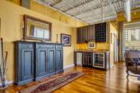 The wet bar includes an ice maker, wine bottle storage, and a mini fridge.