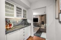 Wet bar with leathered stone countertop and backsplash (2024)