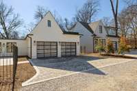 A view of the two car garage attached to the main house and the guesthouse to the right.