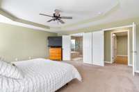 Oversized Primary Suite has trey ceilng with ceiling fan and well kept carpet; Flows into the Primary Bath with soaking tub/tile shower walk in closet and SURPRISE closet/storage